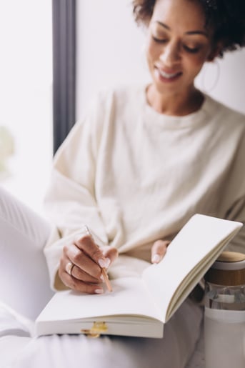 black-woman-dressed-white-writing-notebook